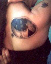 Very unique tattoo of a round window with a guy inside.JPG