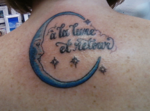 Moon and letters tattoos on the upper back.PNG