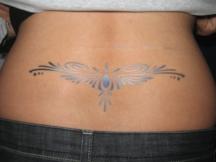 tribal silver tattoo on lower back.jpg